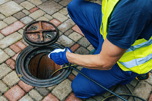 Sewer Line Hydrojetting - CME Sewer Services image showing a man performing hydrojetting.